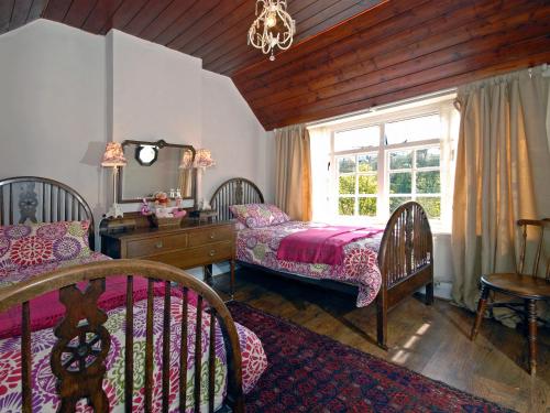 a bedroom with a bed and a dresser and a window at Crows Cottage in Fishguard