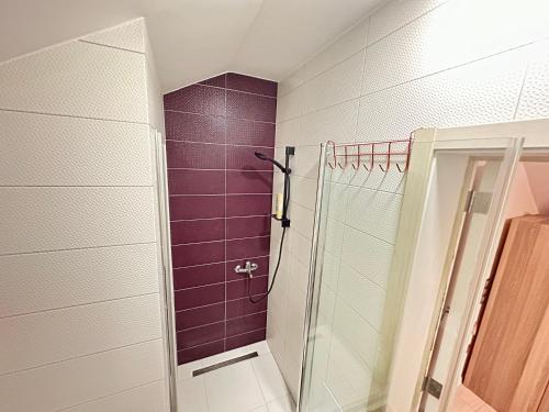 La salle de bains est pourvue d'une douche avec du carrelage violet. dans l'établissement Lovely studio apartament, à Pristina