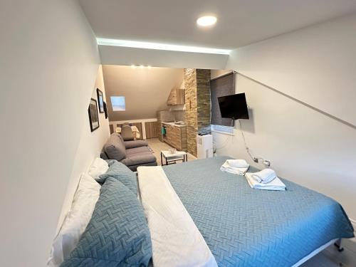 - une chambre avec un grand lit et un canapé dans l'établissement Lovely studio apartament, à Pristina