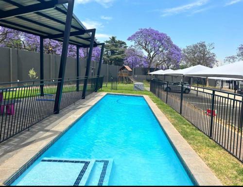 a swimming pool in a yard with a fence at Green with Envy-Luxury Apartment- No Loadshedding in Johannesburg