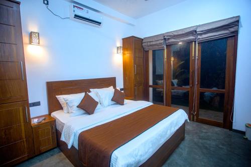 a bedroom with a large bed and a window at The Shades Galle in Galle