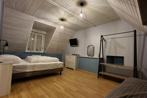 une chambre avec un lit et une télévision dans l'établissement Une petite maison du Rozel - gite tout confort, à Le Rozel