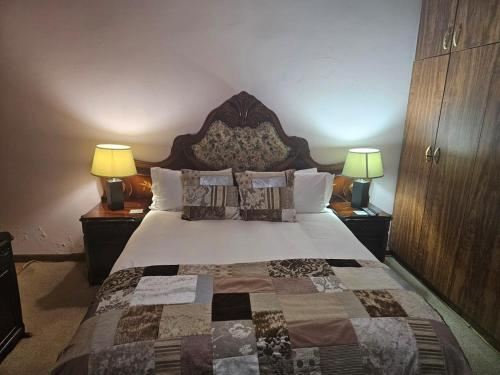 um quarto com uma cama grande e 2 candeeiros em Badi's B&B Guest house em Middledrift