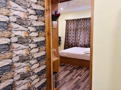 uma sala com uma parede de pedra e um quarto em Lit Homestay em Srinagar