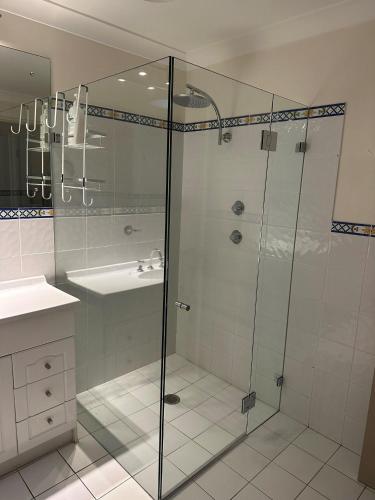 a bathroom with a shower and a sink at Paradiso, 3,4 Laman Street - Comfortable unit with water views, aircon, solar heated pool and in the heart of town in Nelson Bay