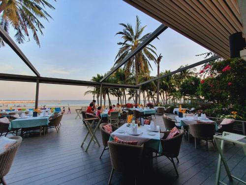 ホアヒンにあるAnantasila Beach Resort Hua Hinのビーチ沿いのレストラン(テーブル、椅子付)