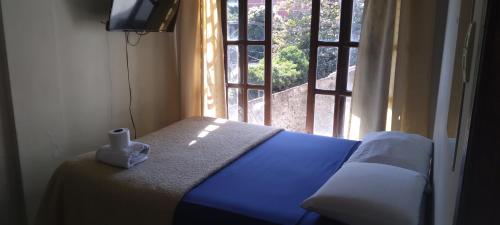 a bed in a room with a window with a candle on it at Safety and Comfort in Santa Cruz de la Sierra