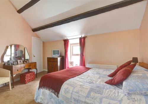 a bedroom with a large bed with red pillows at Ty Nain in Caernarfon