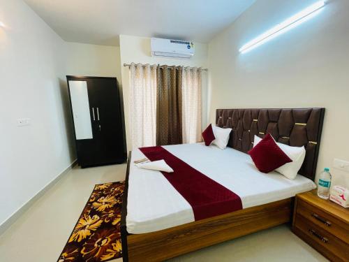 1 dormitorio con 1 cama grande con almohadas rojas en ALanKrita Homes en Lucknow