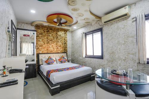 a bedroom with a bed and a glass table at FabHotel Greenland Classic - Bhubaneswar Airport in Bhubaneshwar