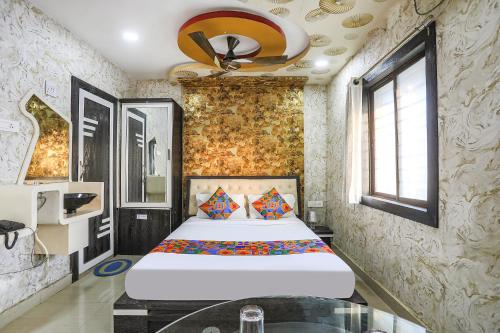 sypialnia z dużym łóżkiem i wentylatorem sufitowym w obiekcie FabExpress Greenland Classic w mieście Bhubaneswar