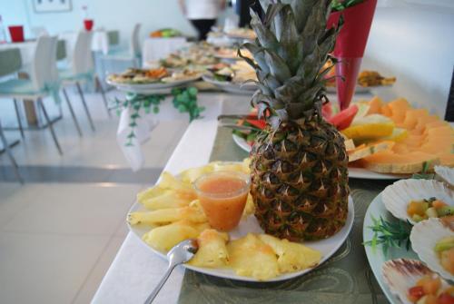 a table with plates of food with a pineapple on it at Residence Aprilia in Grado
