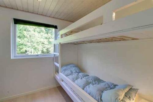 ein kleines Schlafzimmer mit einem Etagenbett und einem Fenster in der Unterkunft Holiday Home In Quiet Neighborhood in Hals