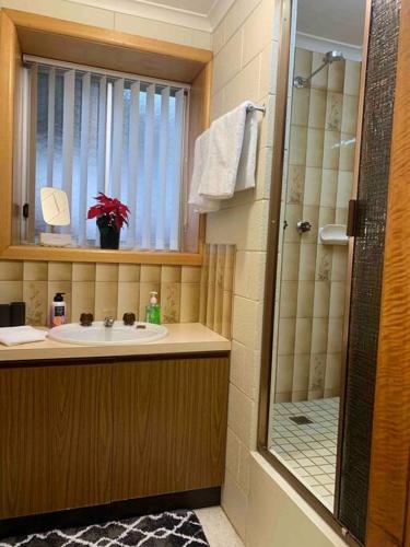 a bathroom with a sink and a shower at Wombats Den A warm and cosy semi underground retreat in Howrah