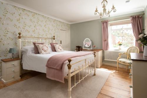 a bedroom with a white bed and a mirror at Owl Cottage in Morpeth