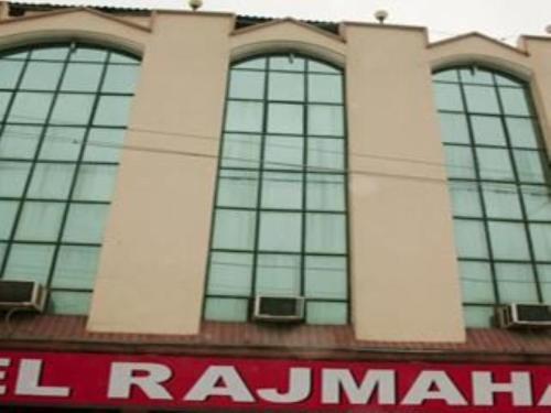 - un bâtiment avec trois fenêtres et un panneau rouge dans l'établissement Hotel Rajmahal, Rudrapur, à Rudrapur