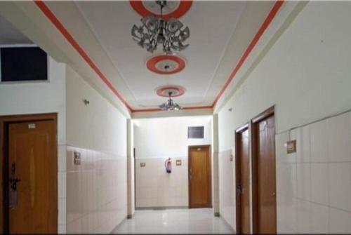 Cette chambre dispose d'un plafond orné d'un lustre. dans l'établissement Hotel Rajmahal, Rudrapur, à Rudrapur