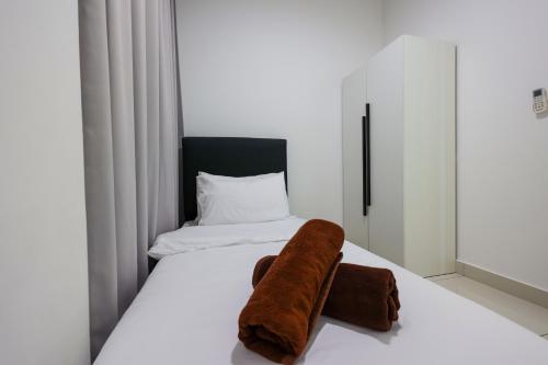 a bedroom with a bed with a towel on it at Greenfield Residence, Bandar Sunway by The Comfort Zone in Petaling Jaya