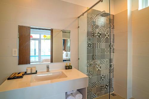a bathroom with a sink and a glass shower at White House Central Villa in Hoi An