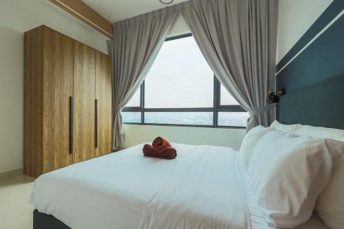 a bedroom with a bed with a red hat on it at Greenfield Residence, Bandar Sunway by The Comfort Zone in Petaling Jaya