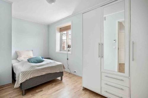 1 dormitorio con 1 cama y armario blanco grande en Warm and lovely apartment with free parking en Tromsø