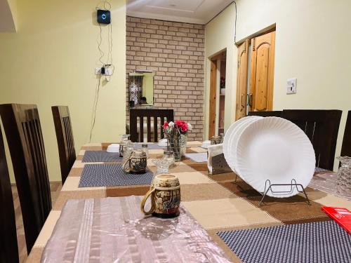 uma mesa de jantar com uma toalha de mesa e uma cadeira branca em Lit Homestay em Srinagar