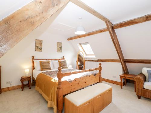 ein Schlafzimmer mit einem Holzbett im Dachgeschoss in der Unterkunft Mistletoe Cottage in Usk