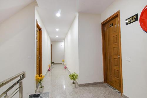 a hallway with a wooden door and some plants at Hotel HC South Crown in Mohali