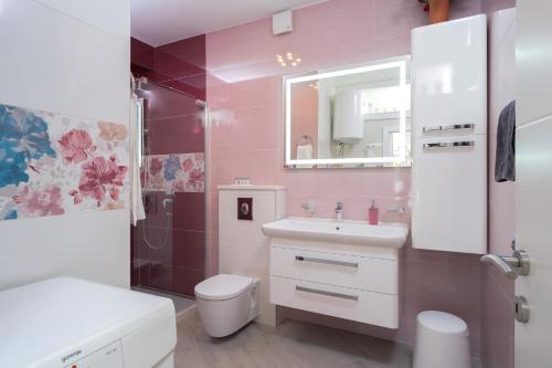 La salle de bains est pourvue d'un lavabo, de toilettes et d'un miroir. dans l'établissement Villa Capitis in the center- Luxury apartment with swimming pool, à Hvar