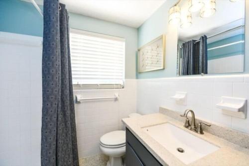 a bathroom with a sink and a toilet and a window at Gulf Home #56546 in Holmes Beach