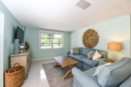 a living room with a blue couch and a table at Gulf Home #56546 in Holmes Beach
