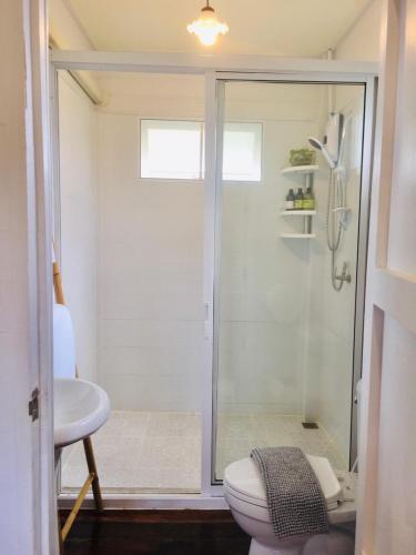 a bathroom with a shower and a toilet and a sink at Huen Chaivaree in Nan