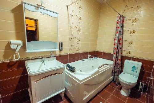 a bathroom with a sink and a toilet and a mirror at Meros Boutique Hotel in Samarkand