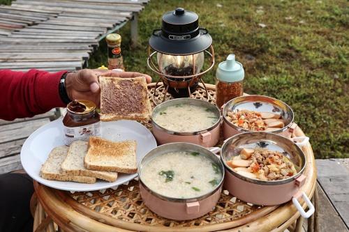 a table with bowls of soup and bread and toast at Vieng Sava in Ban Huai Ti