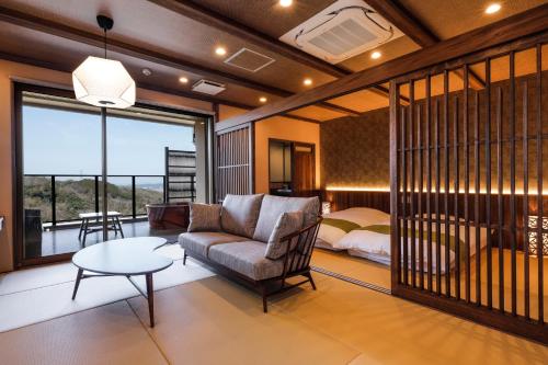 ein Wohnzimmer mit einem Sofa und einem Bett in der Unterkunft Kakimotoya in Sango