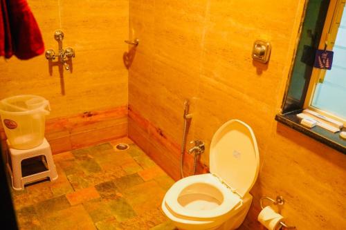 Waves rooms by 29bungalow في آليباغ: حمام مع مرحاض في غرفة خشبية