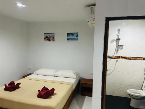 um quarto com uma cama com flores vermelhas em Bang sit Guest House em Phi Phi Don