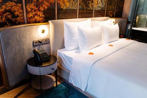 a hotel room with two beds and a phone on a table at La Passion Hanoi Hotel & Spa in Hanoi