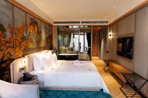 a bedroom with a white bed and a painting on the wall at La Passion Hanoi Hotel & Spa in Hanoi