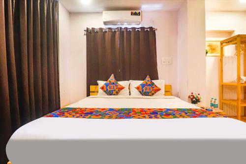 a bedroom with a bed with a black curtain at FabHotel The Green Leaf in Kondapur