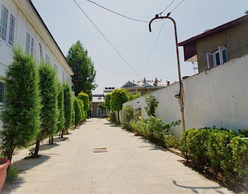 an empty alley with trees and a building at The GoodFind Residency in Srinagar