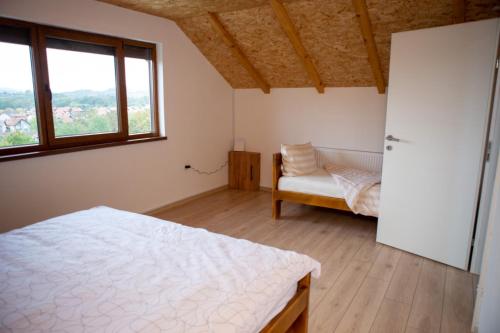 1 dormitorio con 1 cama, 1 silla y 1 ventana en Zivinice Hills, en Živinice
