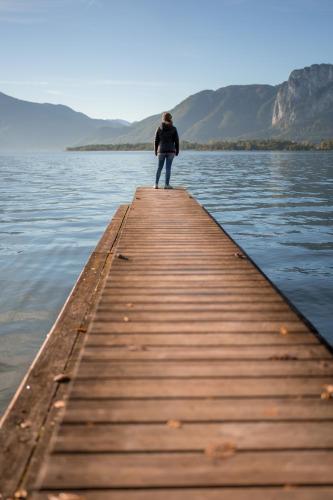 a person standing on a dock in the water at Ferienwohnung Alpenseepark in Mondsee