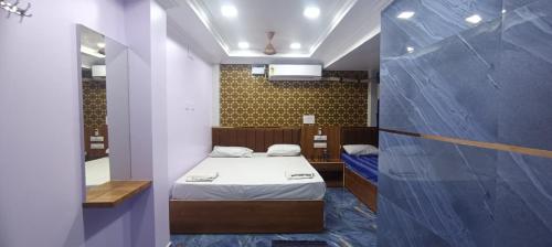 a small room with two beds and a mirror at MERCY INN in Chennai