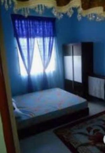 a blue bedroom with a bed and a window at DENAR HOMESTAY CHANGLUN KEDAH in Changlun