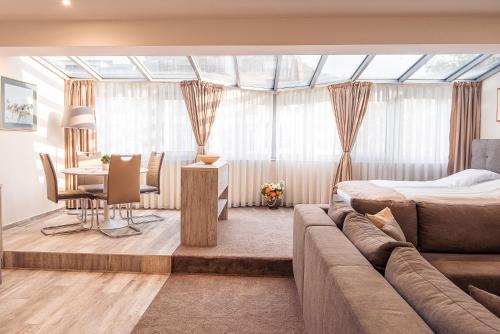 a living room with a bed and a dining room at Cityscape Luxury Suites in Plovdiv