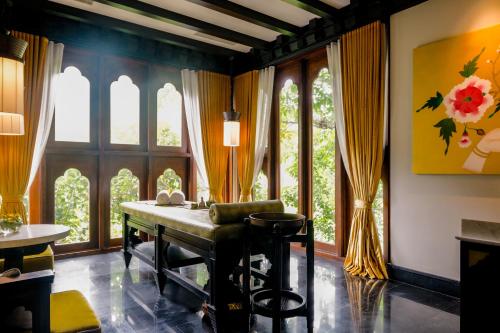 a living room with a table and some windows at Pemako Punakha in Punākha