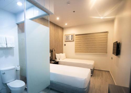 Habitación de hotel con 2 camas y aseo en City Pod Hotel, en Cebú