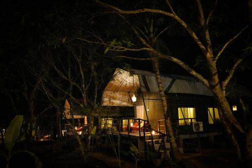 uma casa iluminada à noite com luzes em River Glamping by Gaga bees em Udawalawe