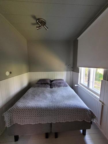 1 dormitorio con 1 cama y ventilador de techo en Hietaman Vierastalo Banksy, en Äänekoski